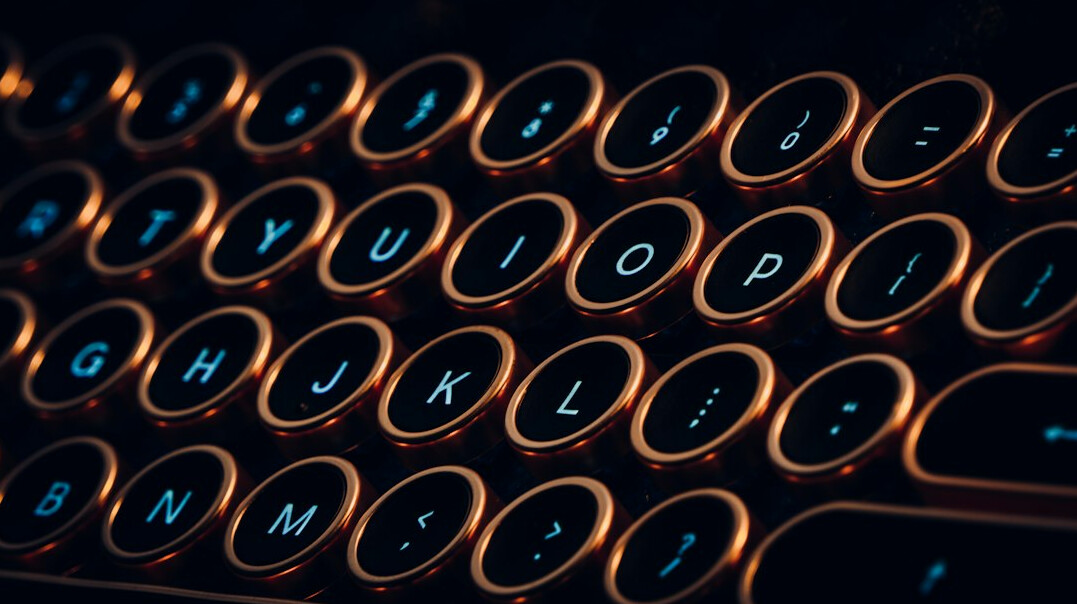 Close-up of hands typing code on a laptop keyboard at night