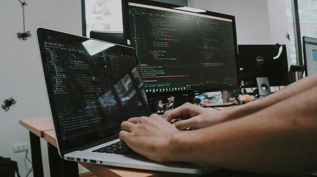 programmer typing code on laptop