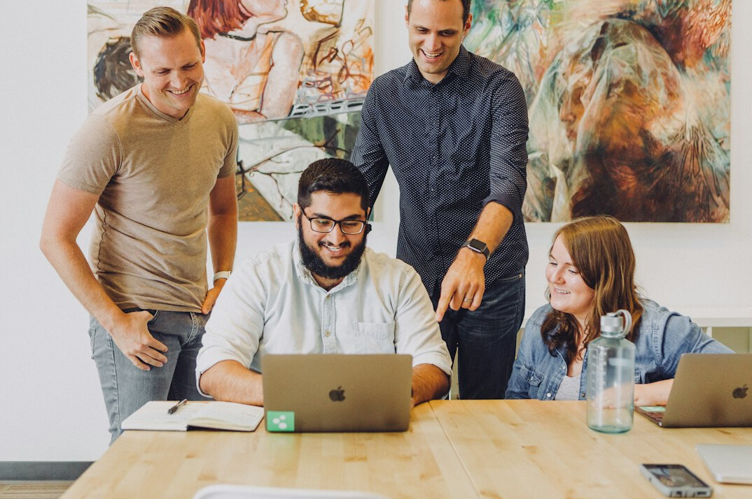 diverse team collaborating on laptop